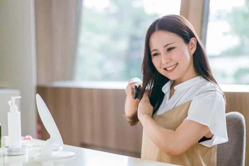 髪のホームケアをする女性