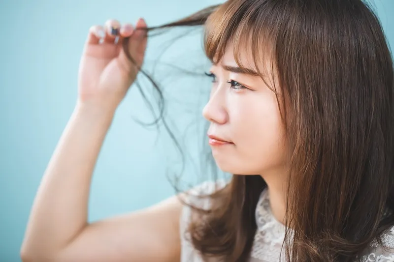 髪のダメージを気にする女性